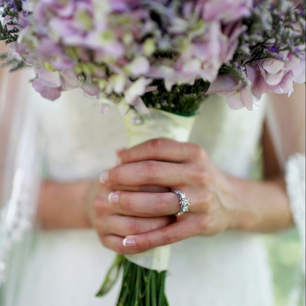 woman-holding-flower-showing-3-stone-carat-ring-difference